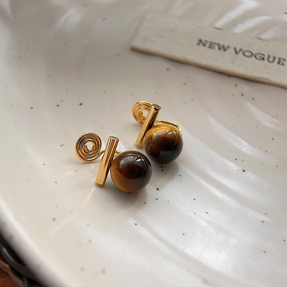 Vintage-inspired tiger's eye resin clip-on earrings, featuring rich brown hues set in a classic alloy with coil clip-on closures, perfect for an earthy, retro aesthetic.