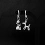 Silver balloon doodle dog clip-on earrings front view displayed on black earring stand