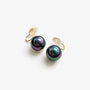 Black pearl clip on earrings with iridescent finish and gold spiral hooks displayed on white background