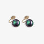 Paire de boucles d'oreilles à clip en perles noires présentées sur une surface blanche douce, capturant leur design classique et intemporel.