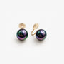 Pair of Black Pearl Clip-On Earrings displayed on a soft white surface, capturing the classic and timeless design.