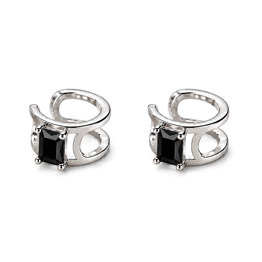 A pair of silver-toned huggie hoop earrings with rectangular black gemstones, shown on a clean white background.