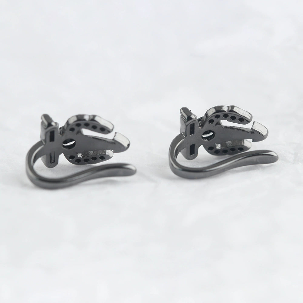Black Trident Clip-On Ear Cuff pair displayed at angle on white background showing metal design and curved ear hook