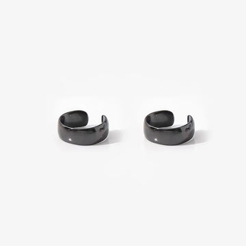 Bold black conch ear cuffs front view on white background, polished curved design