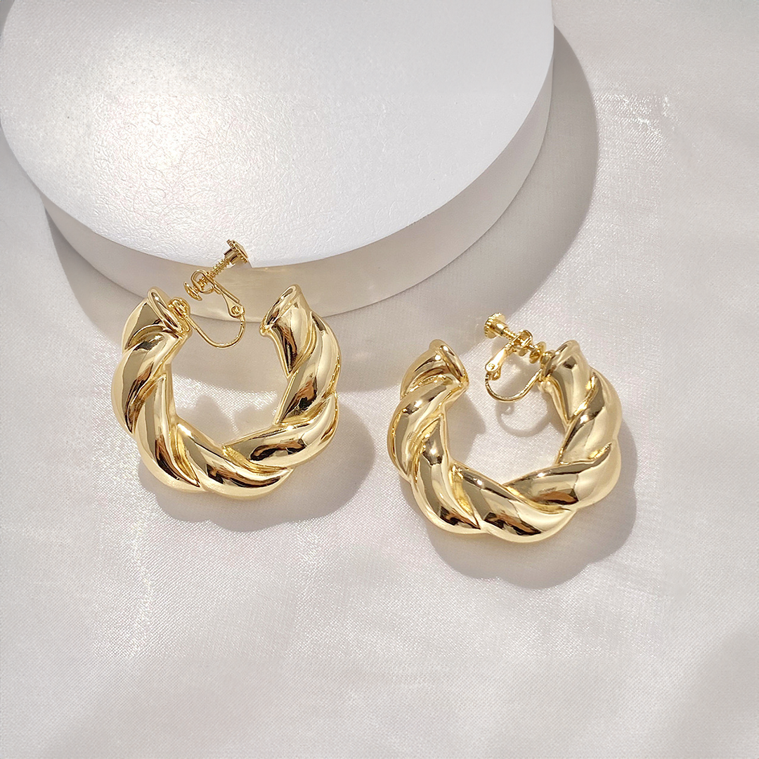 Les boucles d'oreilles Bold Twist Hoop à clip revisitent un accessoire classique avec une touche de modernité. Idéales pour le bureau, ces créoles en alliage doré allient style et praticité grâce à leur fermoir à vis qui assure un maintien parfait. Elles rehaussent à merveille vos tenues, qu'elles soient professionnelles ou décontractées.