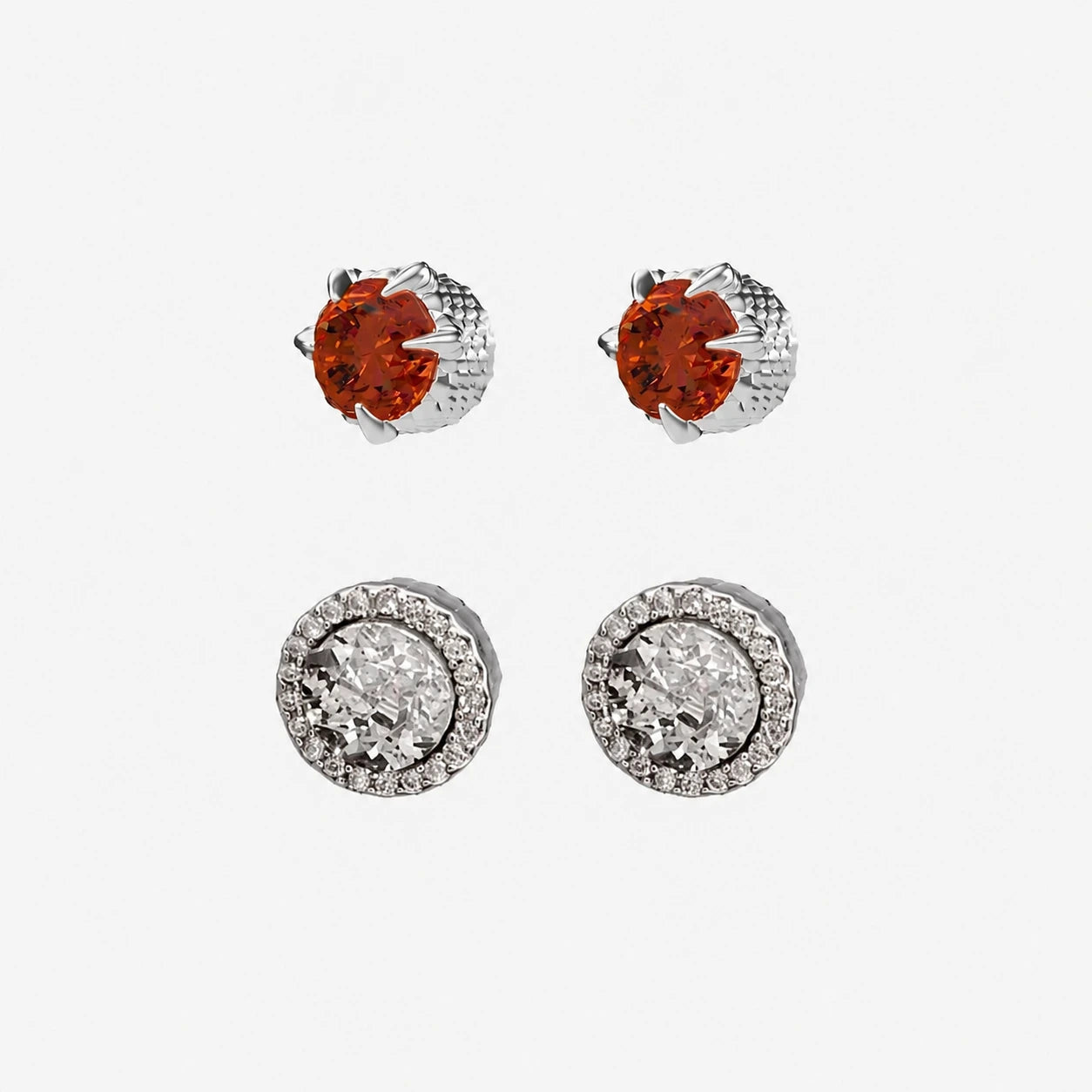 Pair of silver earrings with red ruby and clear gemstones on a white background