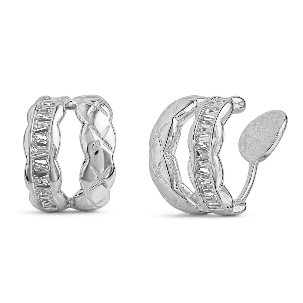 A pair of silver huggie hoop earrings with textured wavy bands and baguette-cut crystal accents, shown on a clean white background.