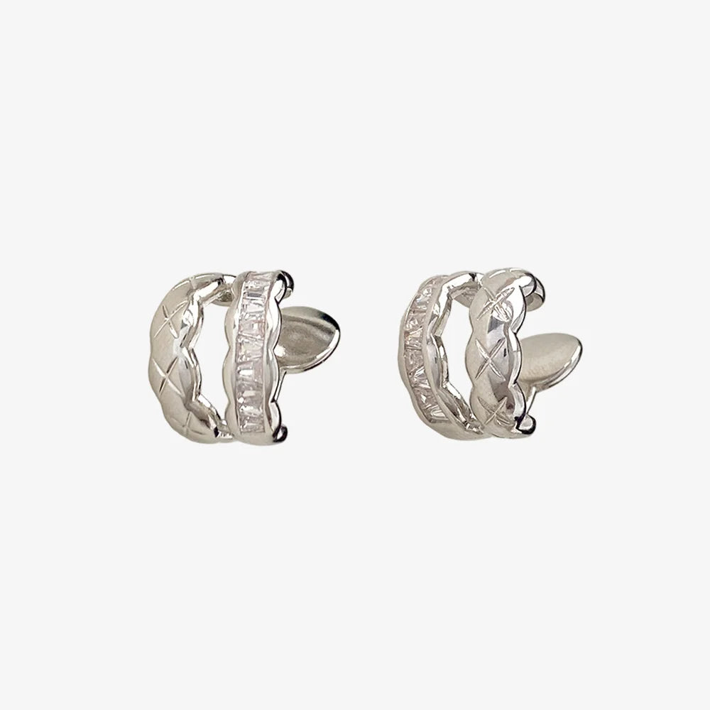Pair of white gold hoop earrings with cubic zirconia on a white background