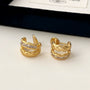 Gold braided baguette clip-on earrings front view on white background with packaging