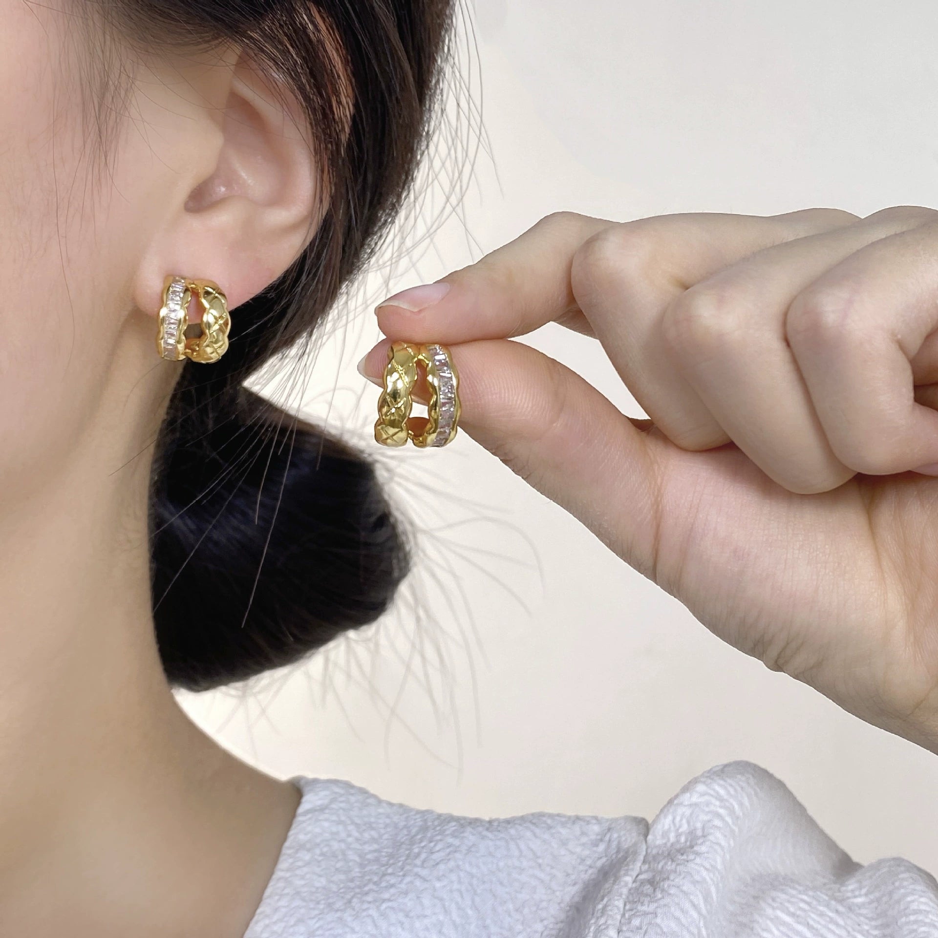 Yellow gold braided baguette clip-on earrings side view on model with dark hair