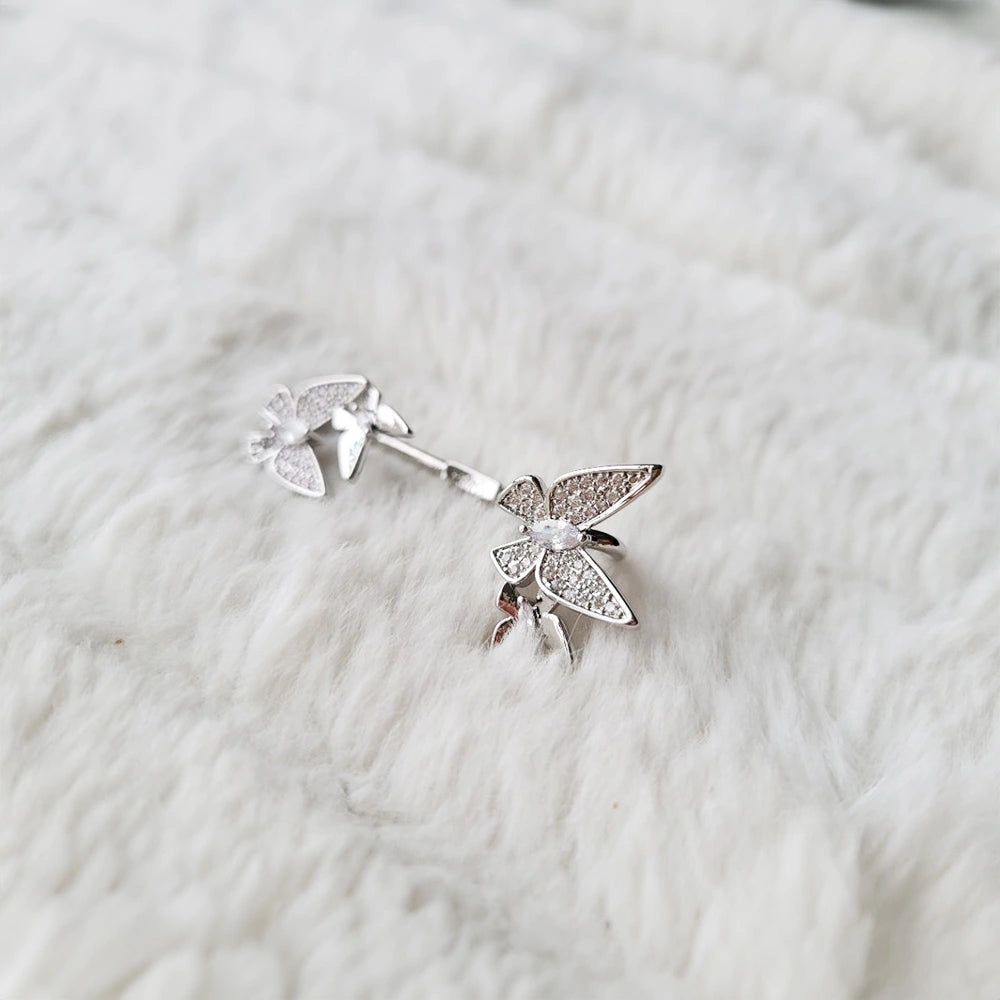 Hand holding the Butterfly Glimmer Ear Cuff, highlighting the detailed butterfly design and sparkling zirconia stones.