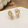 Gold butterfly wing clip-on pearl earrings front view on white background with decorative filigree detailing