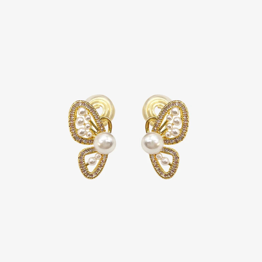 Gold butterfly wing clip-on pearl earrings front view with pearls and crystal detailing on white background