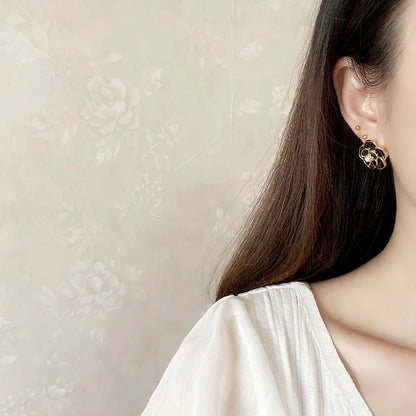 Model showcasing black enamel pearl clip on earrings, perfect for any occasion.