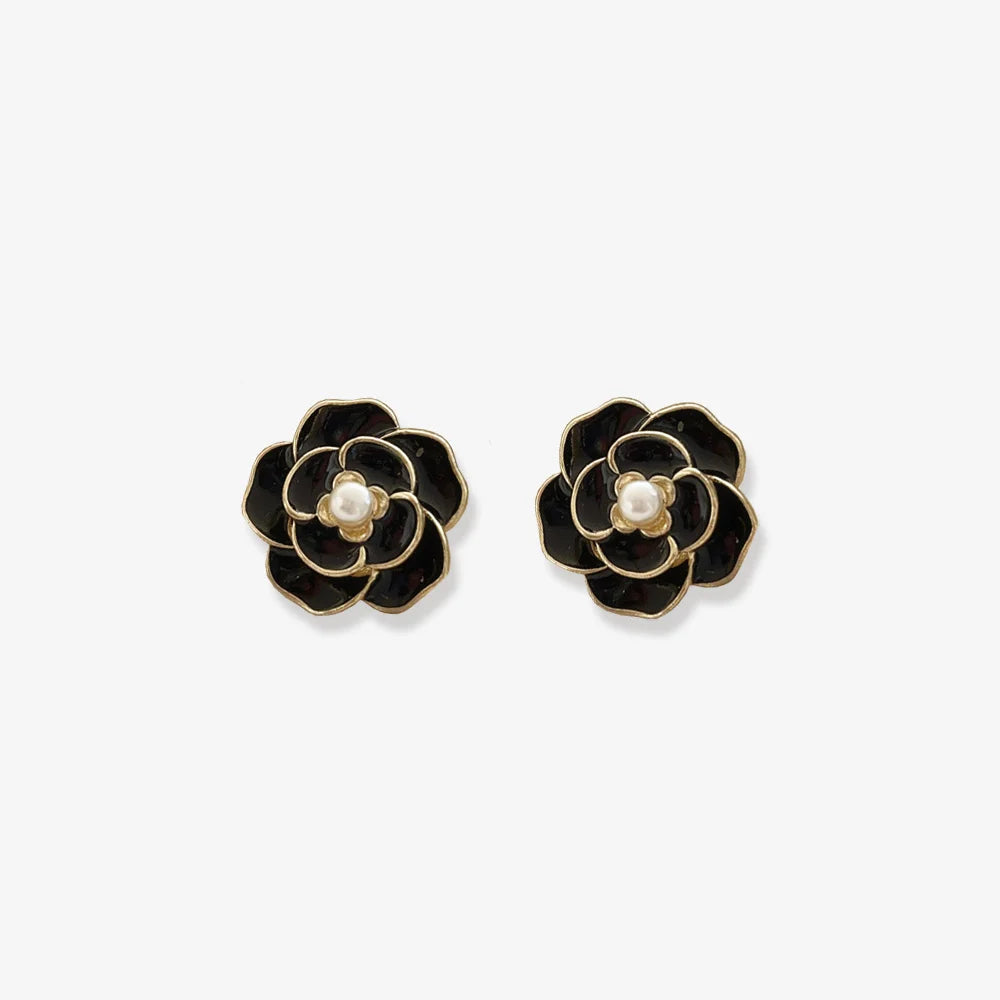 Elegant black enamel clip on earrings for women, featuring a pearl center and flower design.