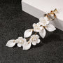 White petal pearl cascade clip-on earrings displayed on black background with gold hardware detail