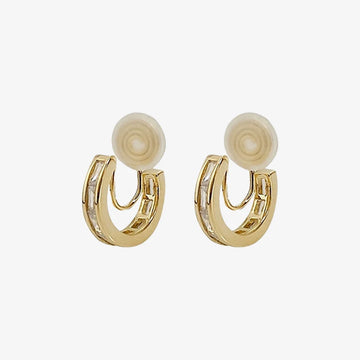 Vue de face de boucles d'oreilles créoles à clip serties de zircons, mettant en valeur les détails des zircons.