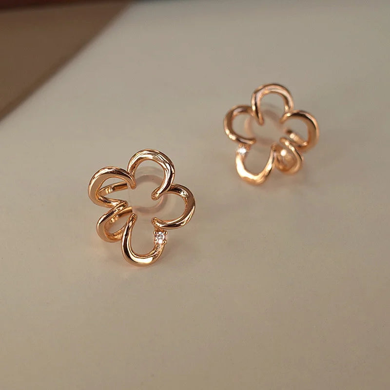 Rose gold cherry blossom floral ear cuffs displayed at angle on white background showing detailed design