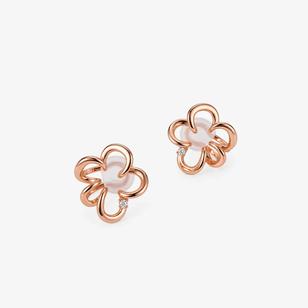 A pair of rose gold flower-shaped stud earrings with a small clear gemstone accent, shown on a clean white background.