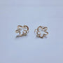 Cherry Blossom Floral Ear Cuffs in white gold, front view on light blue background