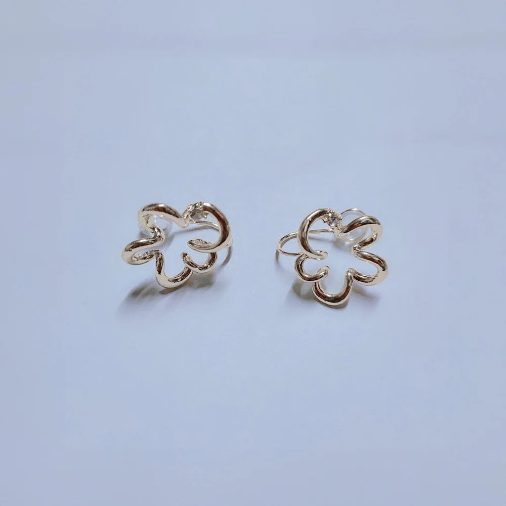 Cherry Blossom Floral Ear Cuffs in white gold, front view on light blue background