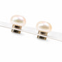 A pair of stud earrings featuring smooth, oval-shaped cream-colored pearls set in polished, displayed on a clean white background.