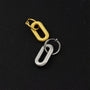 Golden and silver spiral clip-on dangle hoop earrings displayed on black background, showing textured metal finish and design details