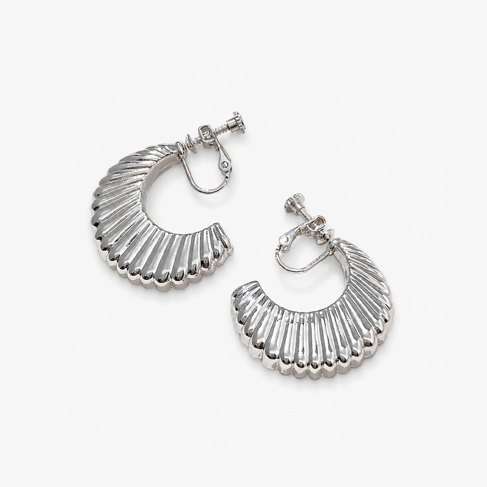 Silver croissant semi hoop clip-on earrings displayed, showing detailed ridged texture and shine from above