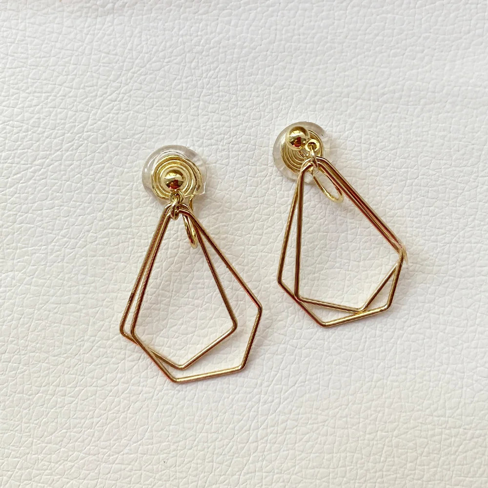 Dainty layered geometric clip-on earrings in gold and rose gold tones displayed on white background