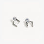 Silver double hoop clip on earrings displayed on white fabric with gold decorative accent below