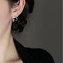 Silver double hoop clip-on earrings side view on model with black hair and neutral background