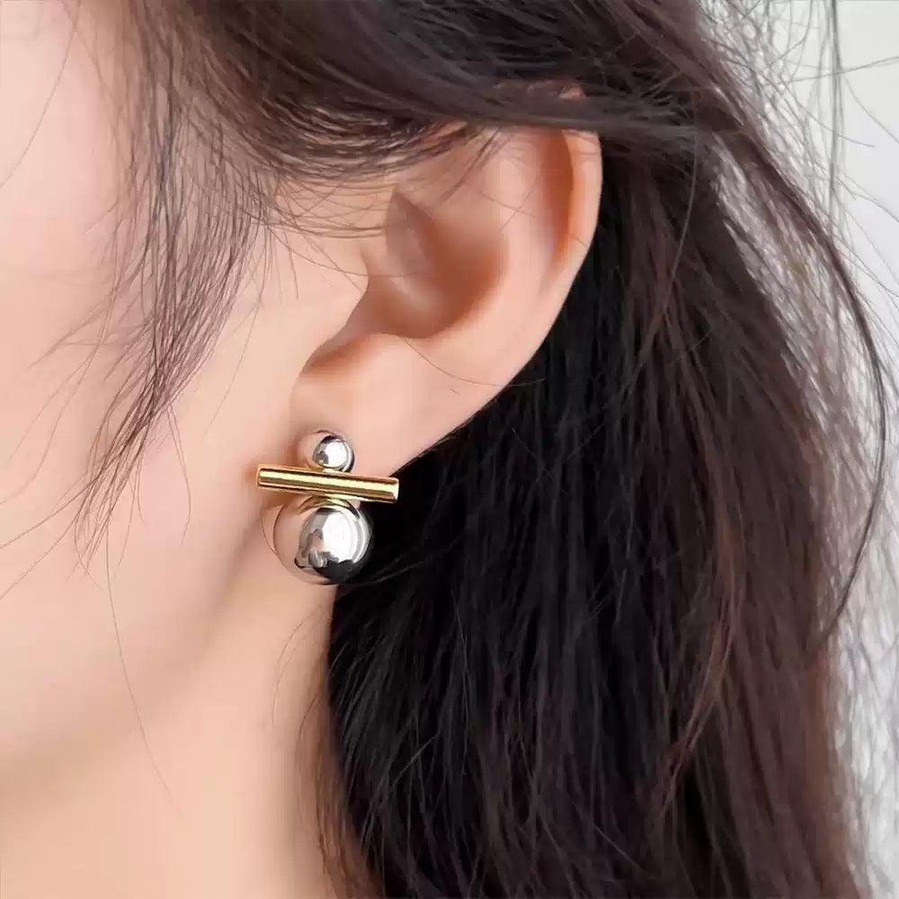 Dual-Tone Sphere and Bar Clip-On Earrings worn by a model, showcasing their modern and minimalist design.