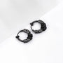 Black Embrace clip-on hoop earrings with decorative dragon head ends, angled view on white background