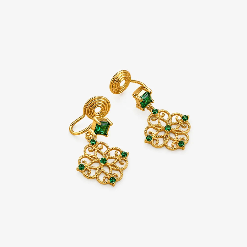 A pair of gold dangle earrings with small green gemstone accents, displayed on a clean white background.
