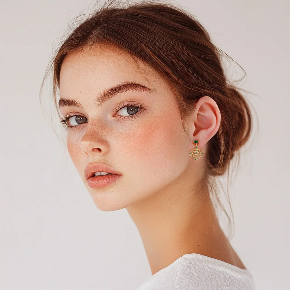 Emerald filigree dangle clip-on earrings side profile view on model with white background