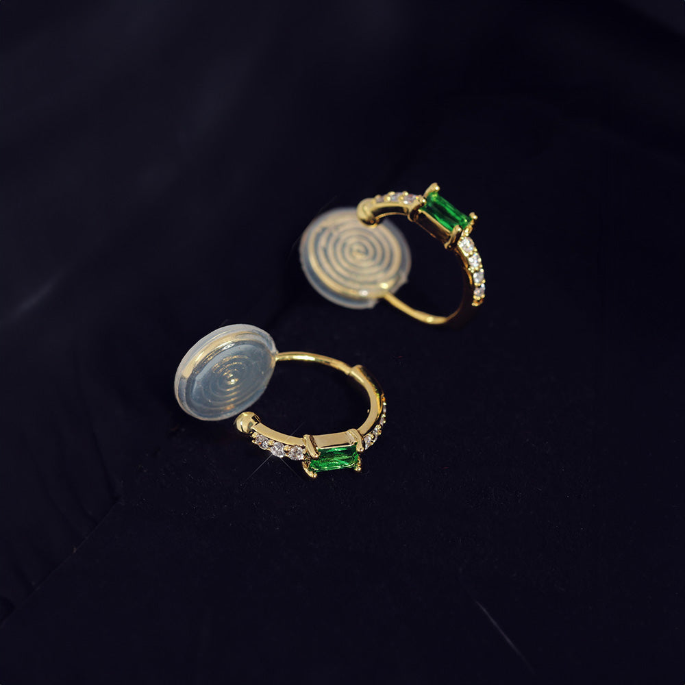 Adorn your ears with the beauty of these Emerald Huggie Clip-on Earrings, where luxury meets convenience. These earrings showcase vibrant green zircon stones that mimic the beauty of real emeralds, set in a classic gold alloy for ultimate appeal.