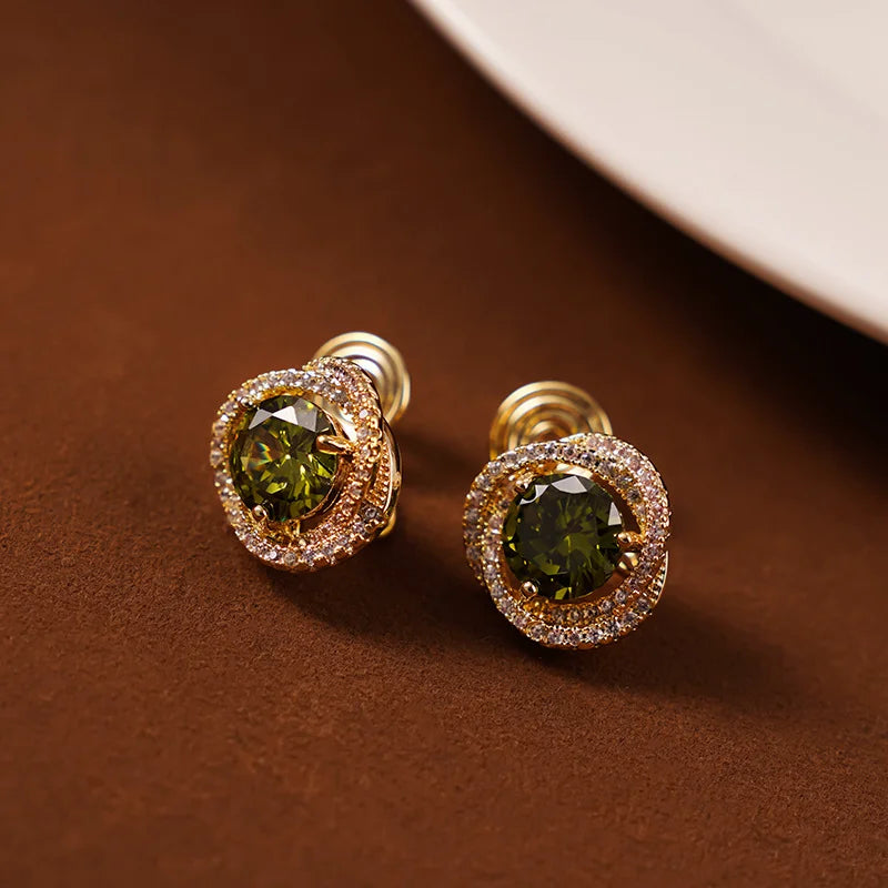 Elegant large emerald zirconia clip-on earrings with gold trim displayed on brown background, front view