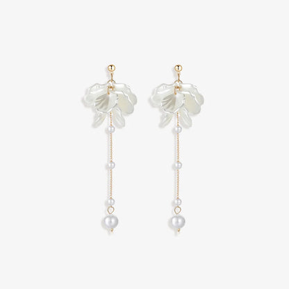 Pair of Floral Pearl Clip Earrings displayed on a soft white surface, capturing the intricate design and luxurious materials.