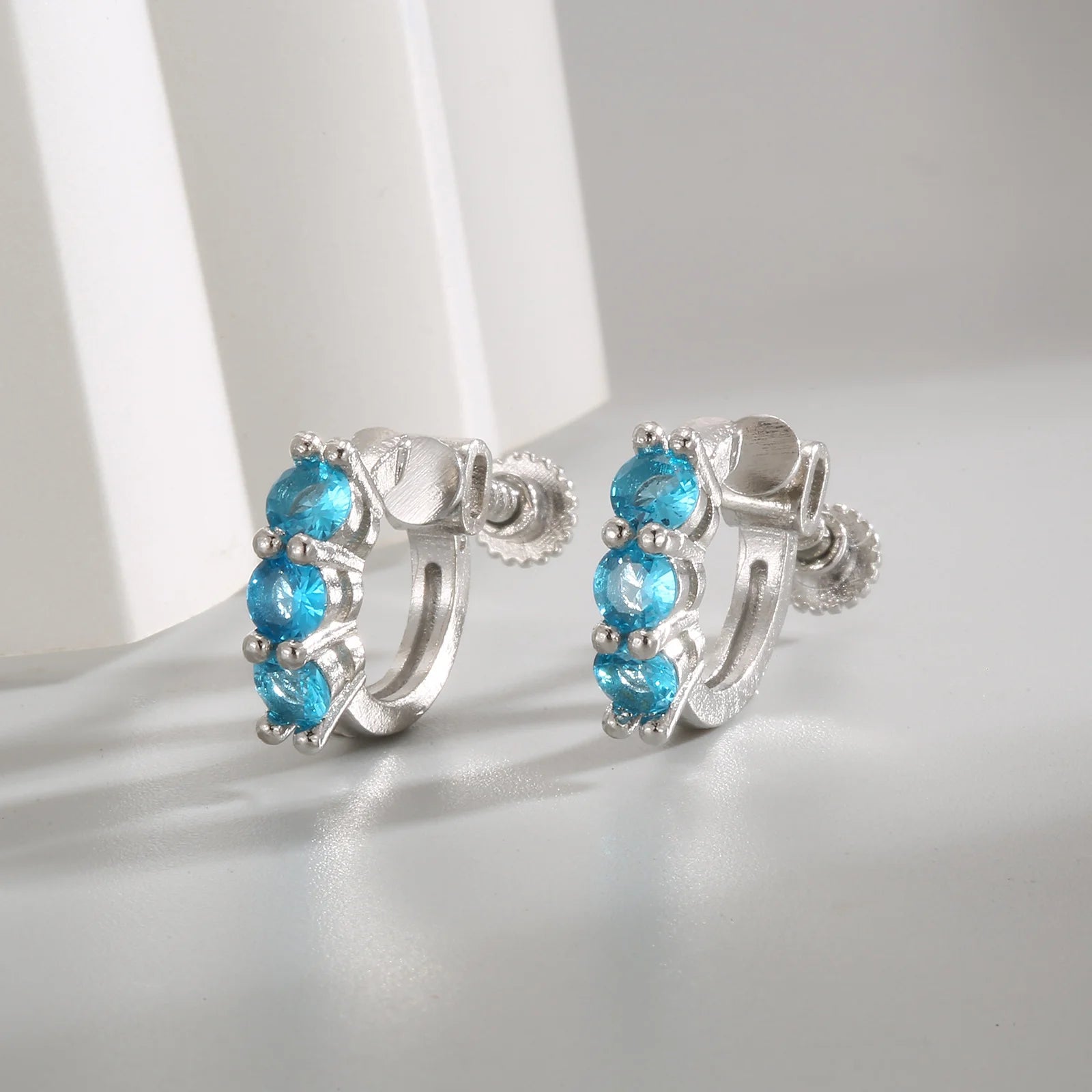 Présentation de boucles d'oreilles à vis en argent serties d'aigue-marine