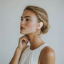 Geometric Harmony Dangle Clip-On Earrings in rose gold worn by woman in side profile view on neutral background