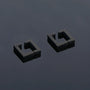 Black geometric square clip-on earrings angled view on gray background showcasing modern minimalist design