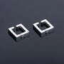 Geometric square clip-on earrings in silver, angled view showing metallic finish and modern design on gray background
