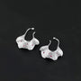 Silver ginkgo leaf ear cuff earrings with ruby accents, front view on black background