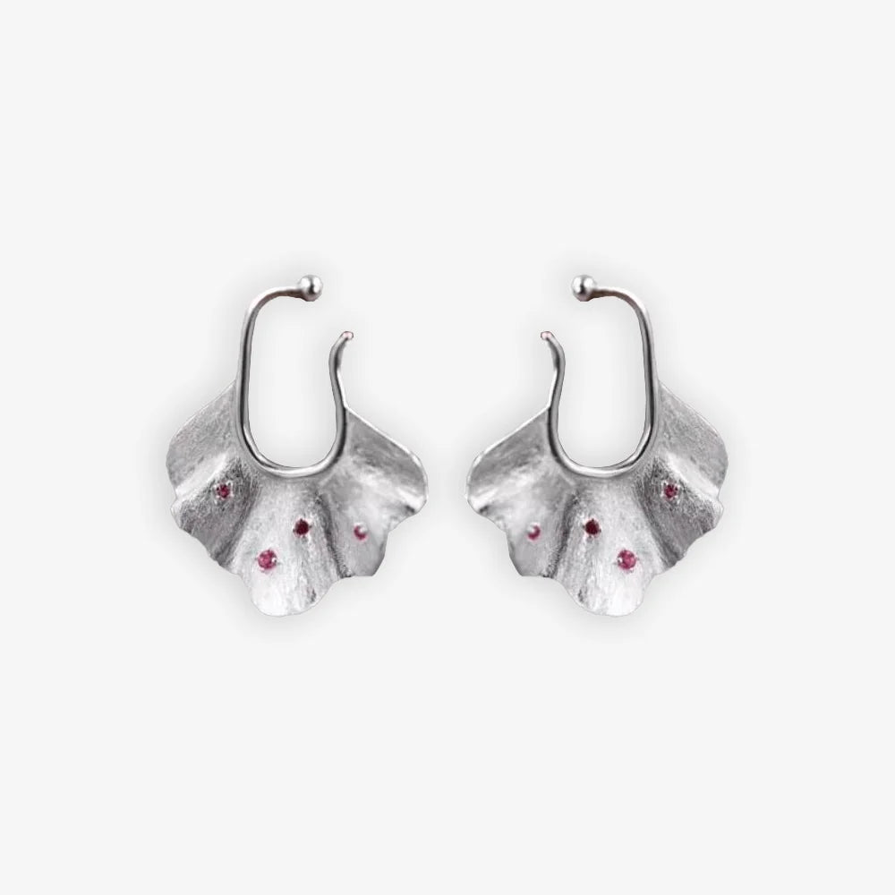 Pair of silver Ginkgo Leaf Ear Conch Cuff Earrings with cherry red zircon accents displayed on a white background, symbolizing nature's eternal elegance and perfect for adding a botanical touch to any outfit.