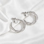 A pair of silver hoop earrings with a textured, twisted design and screwback closures, displayed on a clean white background.
