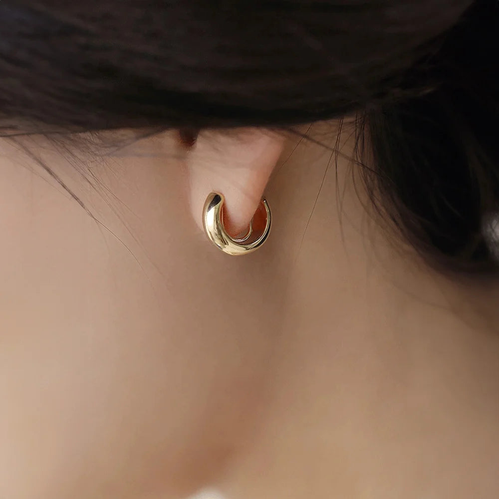 Glossy gold clip-on hoop earrings side view worn on ear, polished finish