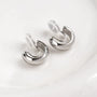 Glossy silver clip-on hoop earrings displayed at an angle on white background showing polished metallic finish and curved design