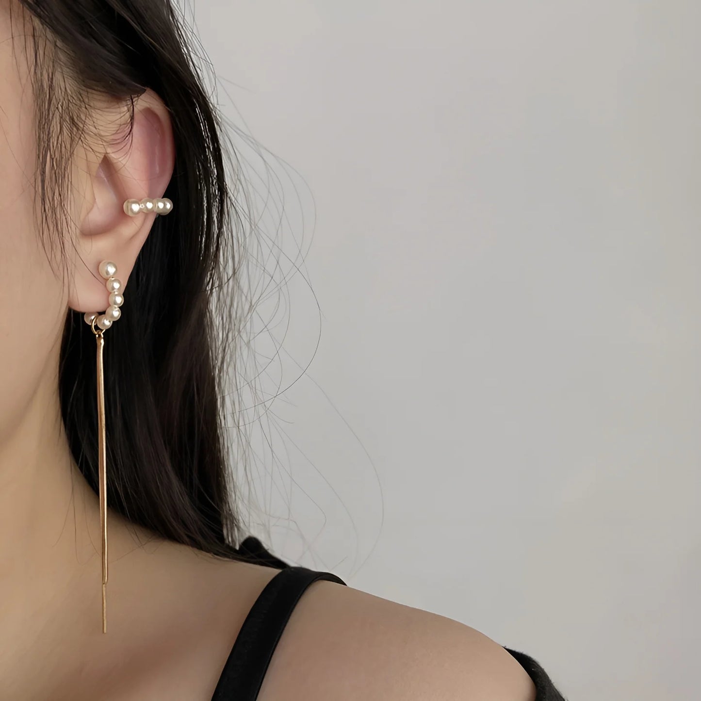 Model wearing the clip on bridal earrings, showcasing a stylish combination of pearls and tassels.