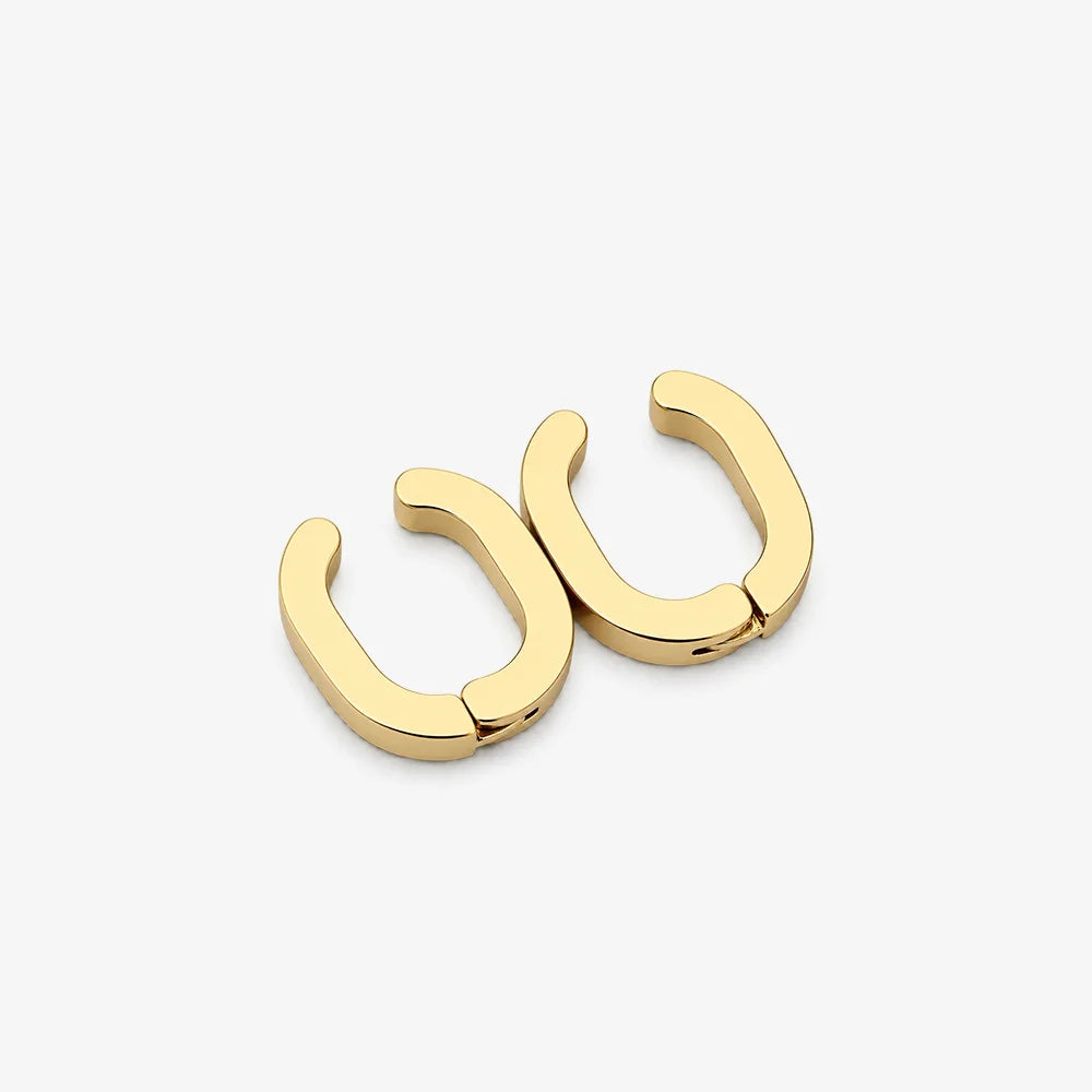 A pair of gold-toned, open hoop earrings with a polished finish, displayed on a clean, light gray background.