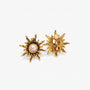 Gold sun clip-on earrings with pearl displayed on white background, showing front and back views of the ornate design